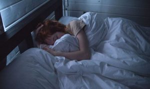 a woman is sleeping under the sheet/ calcium helps sleep
